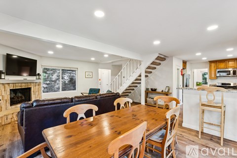 A dining room with a wooden table and chairs.