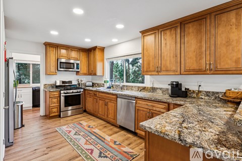 A kitchen with wooden cabinets and granite countertops.
