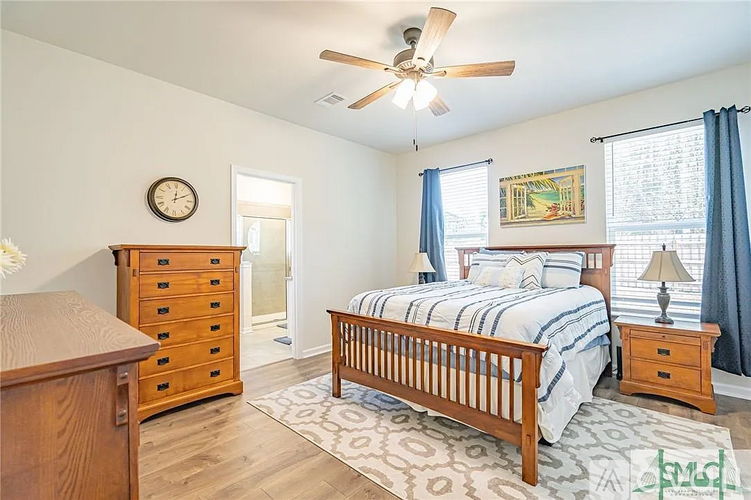 A bedroom with a bed, dresser, and window.