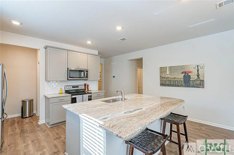 A kitchen with a marble countertop and a painting on the wall.