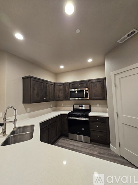 A kitchen with dark brown cabinets and stainless steel appliances.