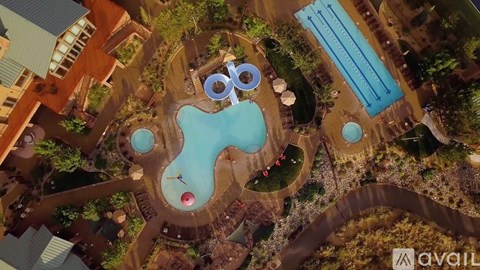 An aerial view of a resort with a large pool and a water slide.