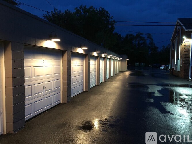 A long row of garage doors are illuminated by lights at night.