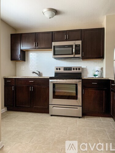 A kitchen with brown cabinets and a stainless steel oven.
