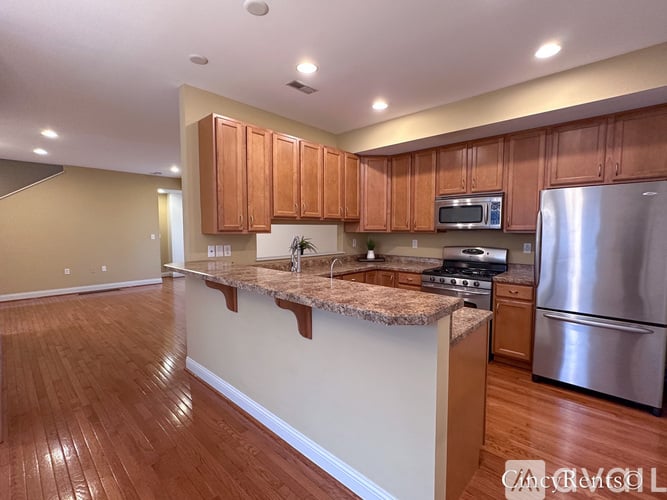 A kitchen with wooden cabinets and a granite countertop.