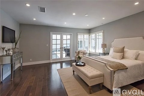 A bedroom with a large bed and a television.