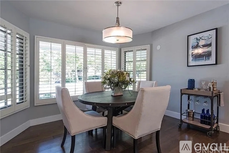 A dining room with a round table and four chairs.