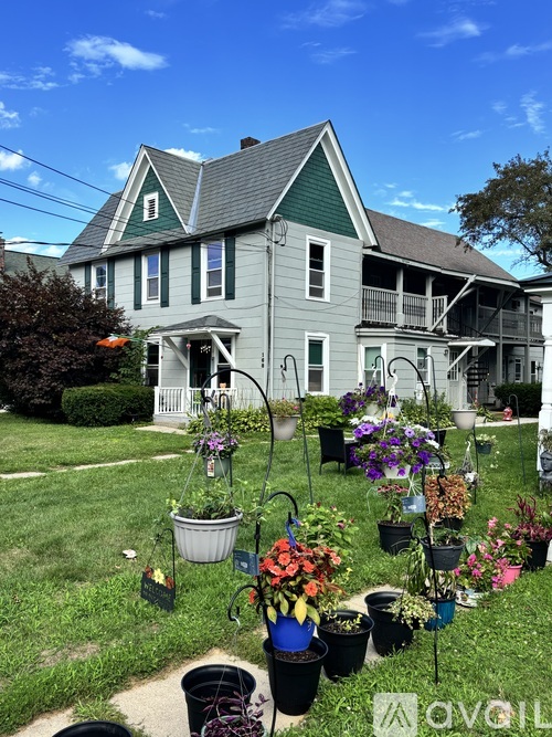 A house with a green roof and a white picket fence.