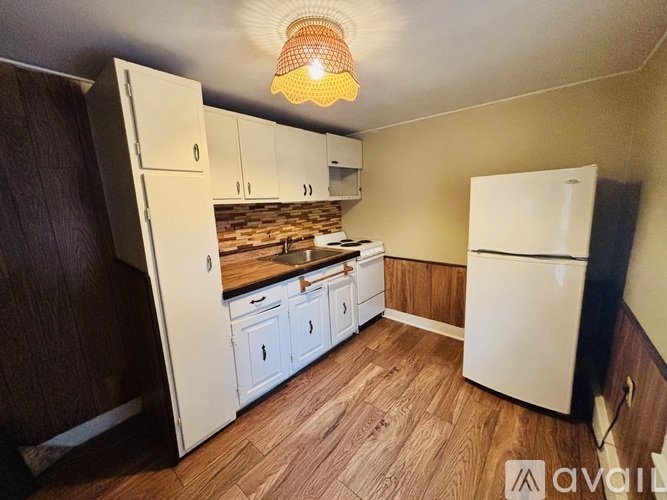 A kitchen with wooden floors and white appliances.