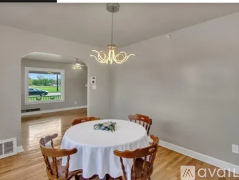 A dining room with a round table set for six.