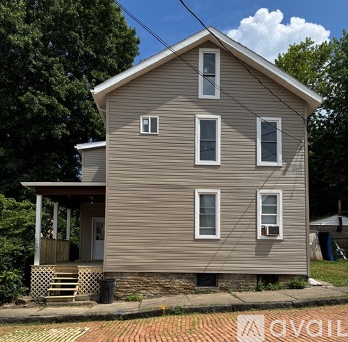 A two-story house with a porch and a covered entryway.
