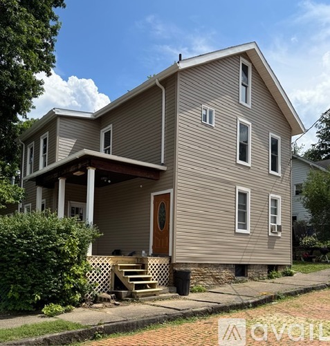 A two-story house with a brown door and white trim.