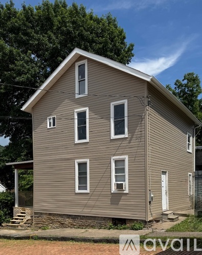 A two-story house with a brown siding and white trim.