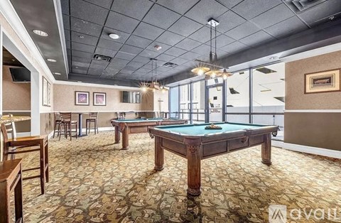 A room with a pool table and a bar area.
