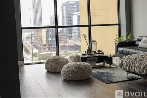 A modern living room with a view of the cityscape outside the large window.