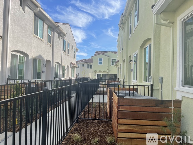 A row of houses with a black fence in front.