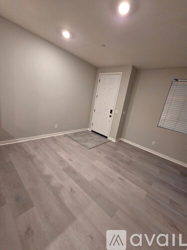 A room with a wooden floor and a white door.