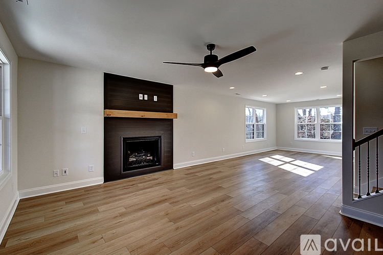 A spacious living room with a fireplace and hardwood floors.