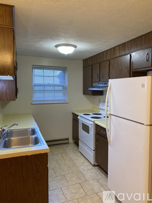 A kitchen with a white refrigerator, white stove, and white sink.