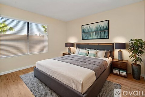 A bedroom with a large bed and a painting on the wall.