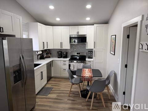 A modern kitchen with a dining table and chairs.