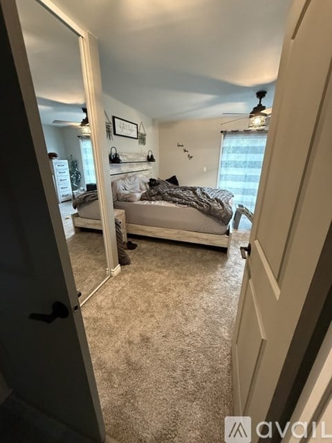 A bedroom with a bed and a mirror on the wall.