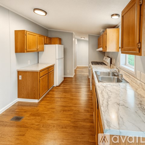 A kitchen with wooden cabinets and a marble countertop.