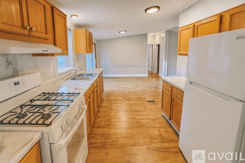 A kitchen with wooden cabinets and a white stove top oven.