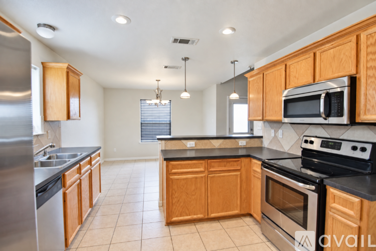 A kitchen with wooden cabinets and black countertops.