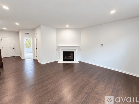 A spacious living room with a fireplace and hardwood floors.