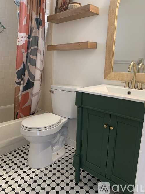 A white toilet sits next to a green cabinet in a bathroom.
