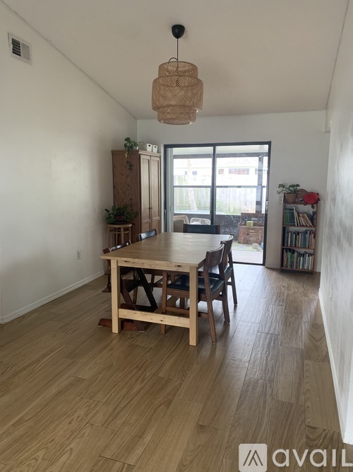 A room with a wooden table and chairs and a window.