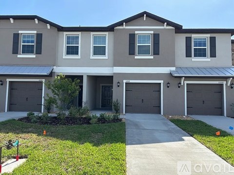 A row of houses with garages and driveways.