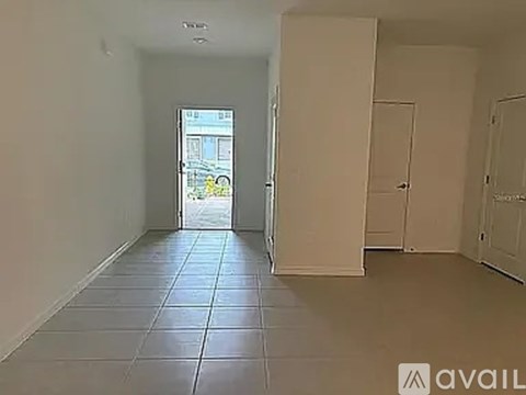 A room with tiled flooring and a doorway leading to another room.
