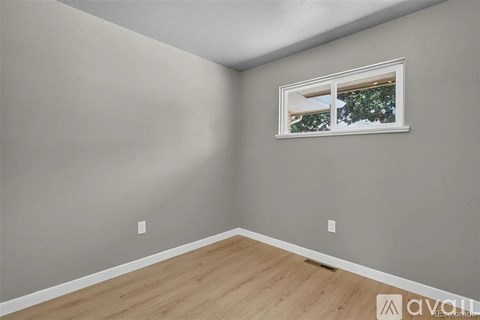 A room with a window showing trees outside.
