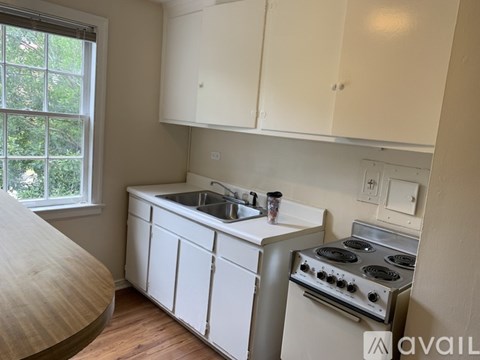 A kitchen with white cabinets and a stove top oven.