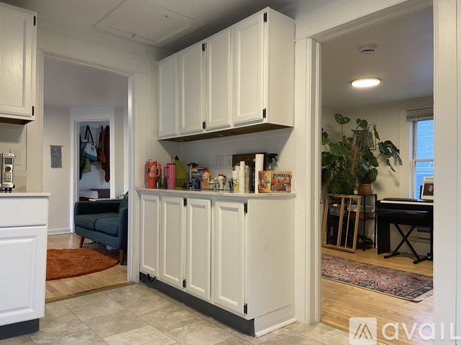 A kitchen with white cabinets and a rug on the floor.