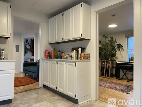 A kitchen with white cabinets and a rug on the floor.