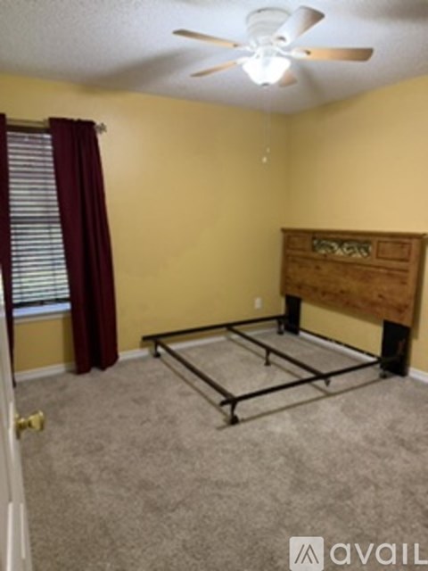 A bedroom with a bed and a ceiling fan.