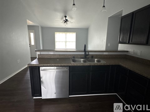 A kitchen with a stainless steel dishwasher and a ceiling fan.