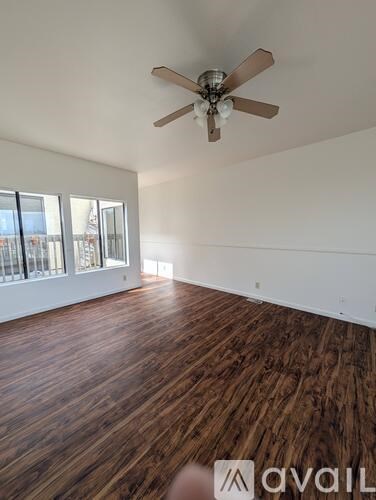 A room with wooden flooring and a ceiling fan.