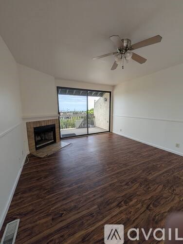 A room with a fireplace and a ceiling fan.
