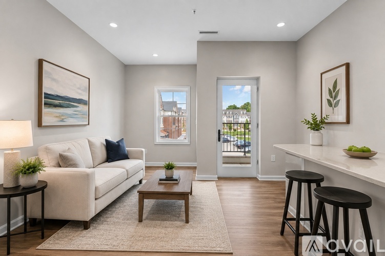 A living room with a white couch, a coffee table, and a painting on the wall.