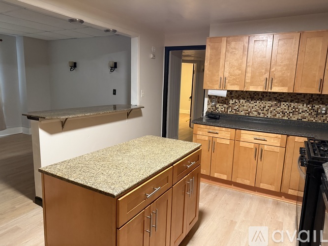 A kitchen with wooden cabinets and a granite countertop.