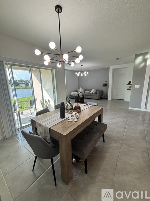 A dining room with a table set for two and a view of a lake outside the window.