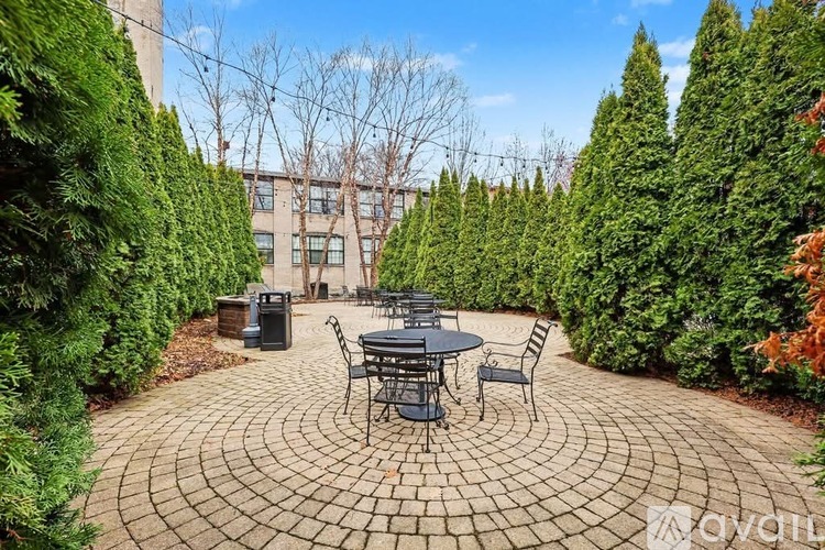 A patio with a table surrounded by green trees.