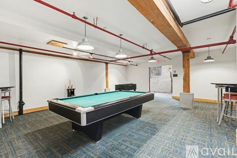 A pool table is in the middle of the room.