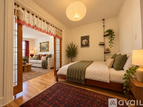 A bedroom with a large bed and a painting on the wall.