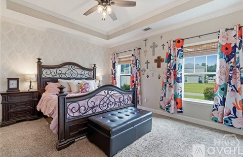 A bedroom with a dark wooden bed and a ceiling fan.