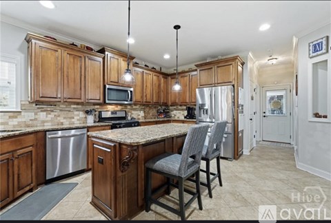A kitchen with wooden cabinets and a granite countertop.